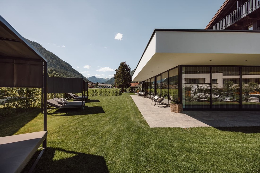 Moderne Terrasse mit Liegest&uuml;hlen und Blick auf Berge vom Hotel loj