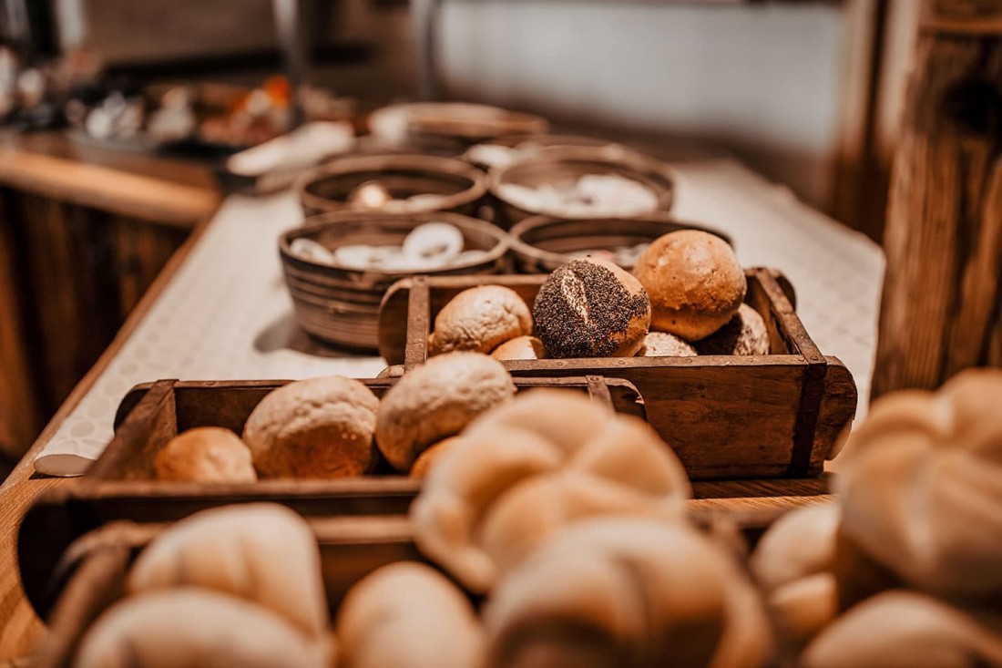 Frische Br&ouml;tchen in Holzkisten auf einem Tisch in einer rustikalen B&auml;ckerei