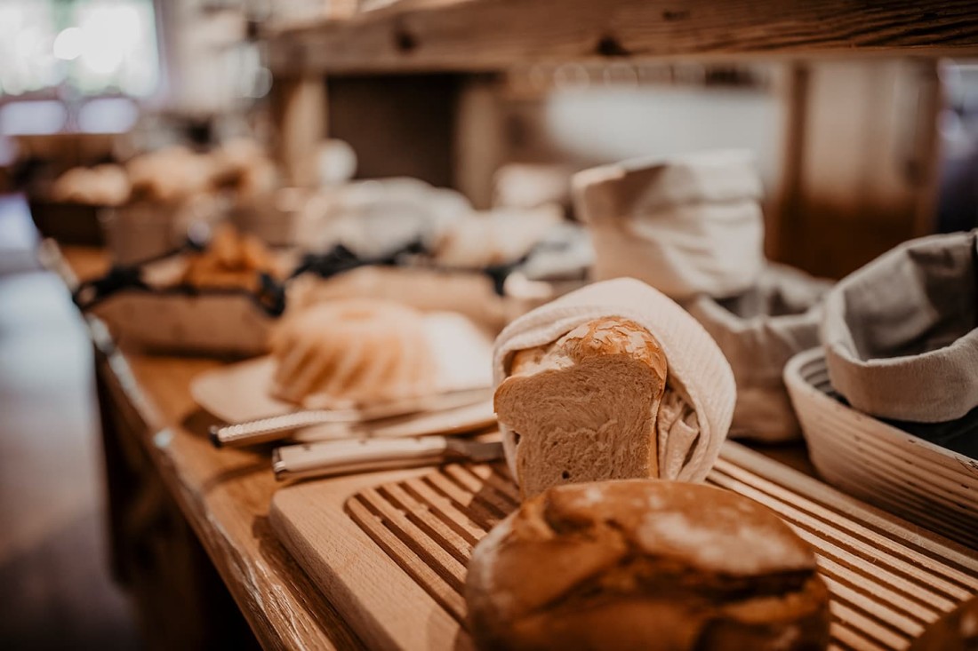 Ein Tisch mit verschiedenen Brotsorten und K&ouml;rben in einem rustikalen Ambiente