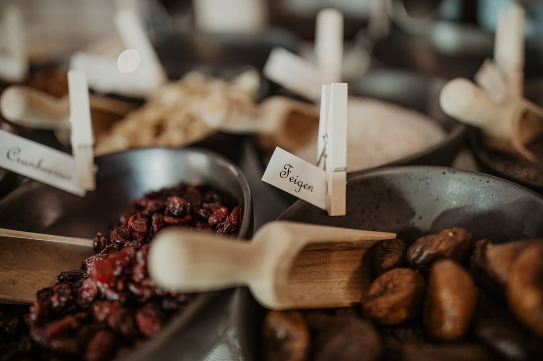 Getrocknete Cranberries und Feigen in Schalen mit Holzschaufeln und Etiketten