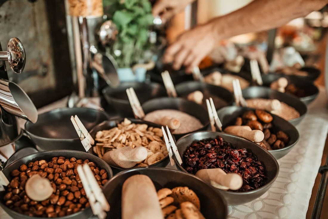 Verschiedene Schalen mit N&uuml;ssen und Trockenfr&uuml;chten auf einem Buffet-Tisch