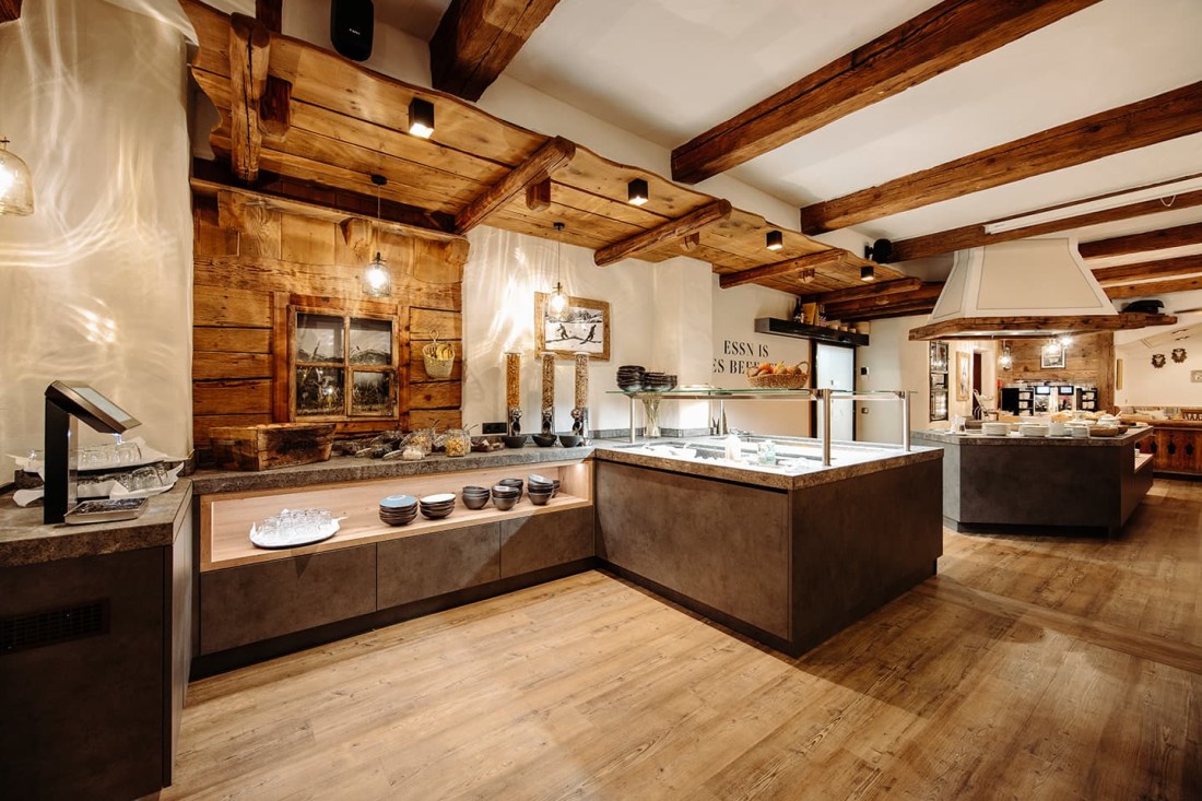 Rustikales Buffet in einem modernen Raum mit Holzbalkendecke und verschiedenen Speisen
