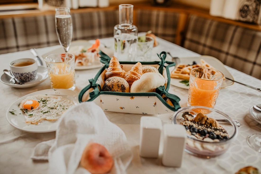 Ein gedeckter Fr&uuml;hst&uuml;ckstisch mit Br&ouml;tchen, Saft und Kaffee
